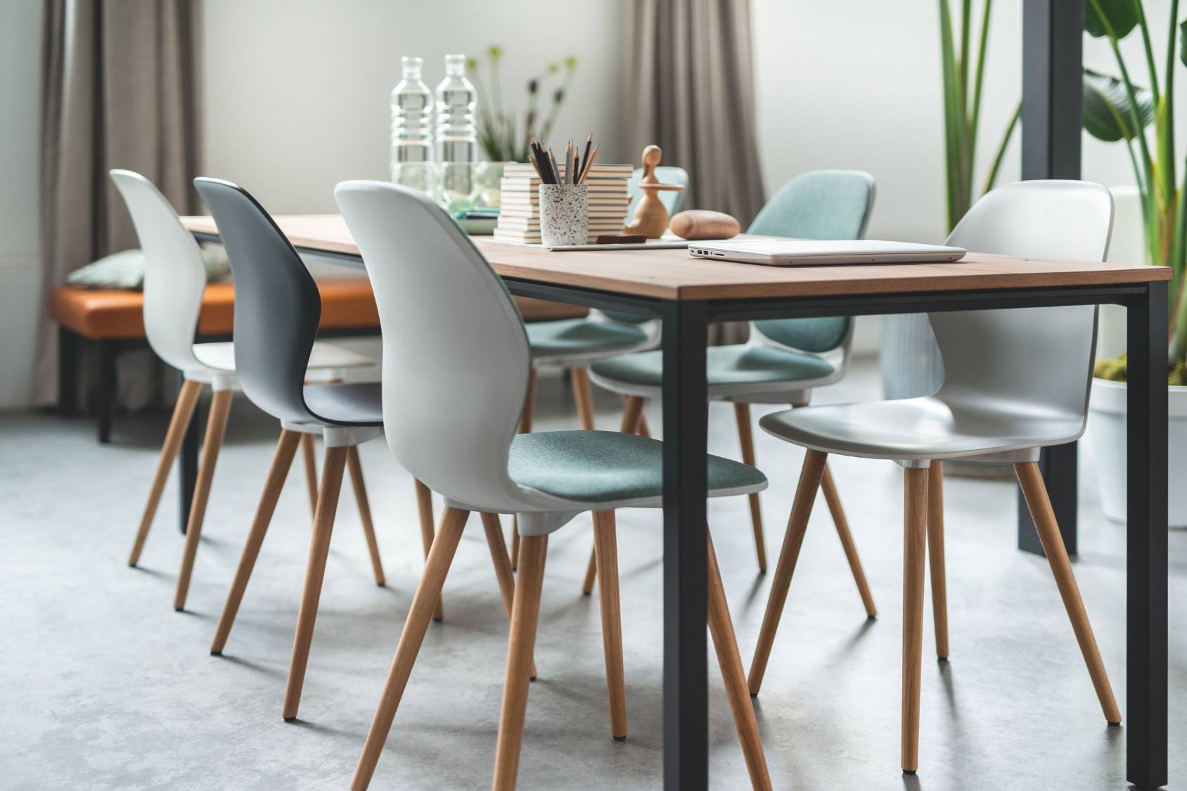 se:spot Stühle mit unterschiedlichen Sitzschalen in modernem Design, Holzbeine, um einen Tisch gruppiert