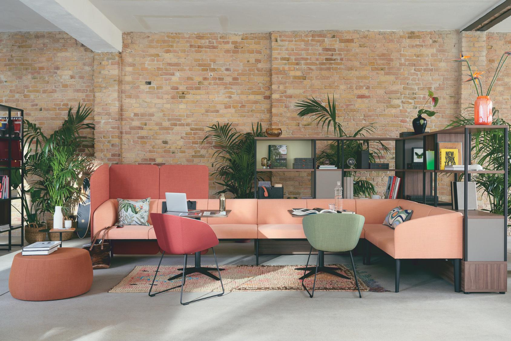 Zwei on spot cosy Bürostühle mit schwarzen Kufengestellen vor einem hellen Sofa in einem modernen Raum mit Backsteinwand
