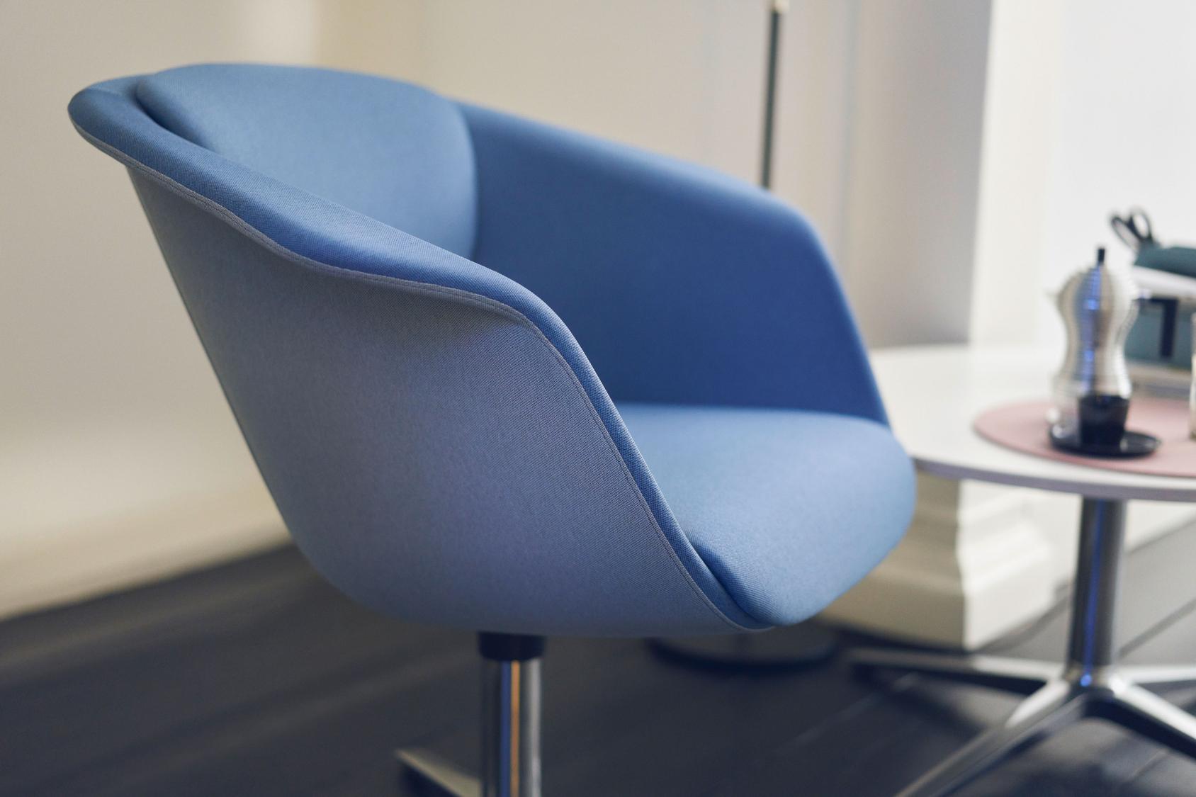 Blauer sweetspot mit gepolstertem Sitz und Rückenlehne auf Metallfuß in modernem Raum