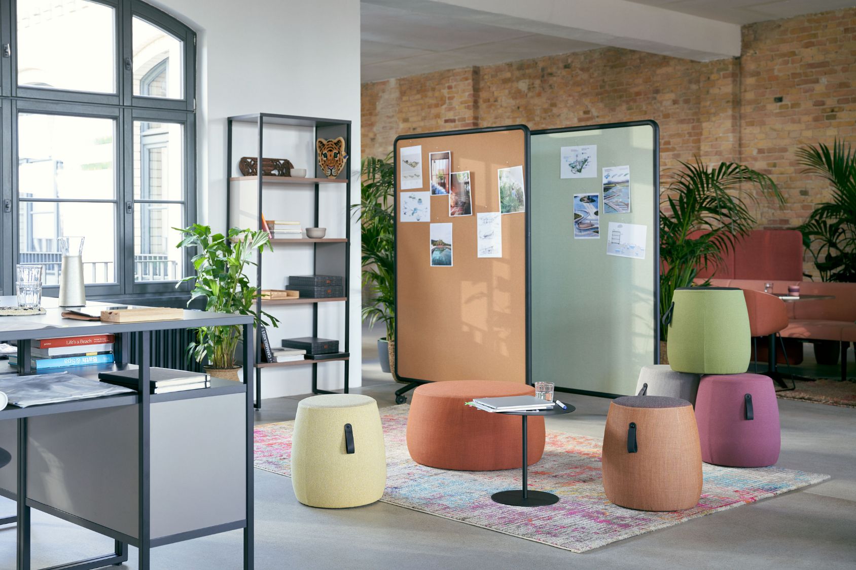 se:dot Hocker in verschiedenen Pastellfarben mit rundem, gepolstertem Design und schwarzem Griff, arrangiert in modernem Büro mit Pflanzen und Trennwänden