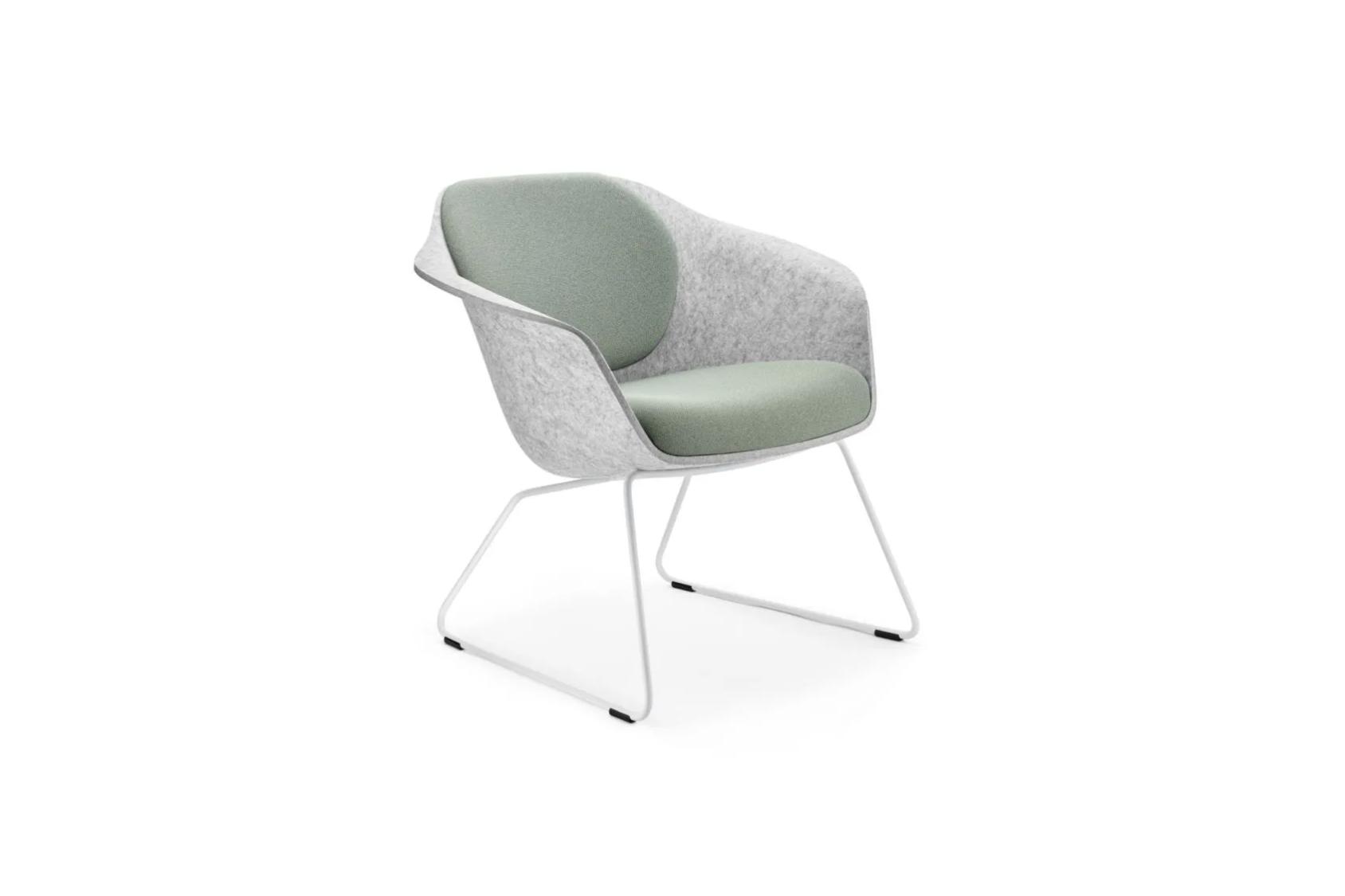 Der Loungesessel se:lounge light mit hellgrauer Schale, grün gepolsterter Sitzfläche und Rückenlehne, auf weißem Kufengestell aus Metall.