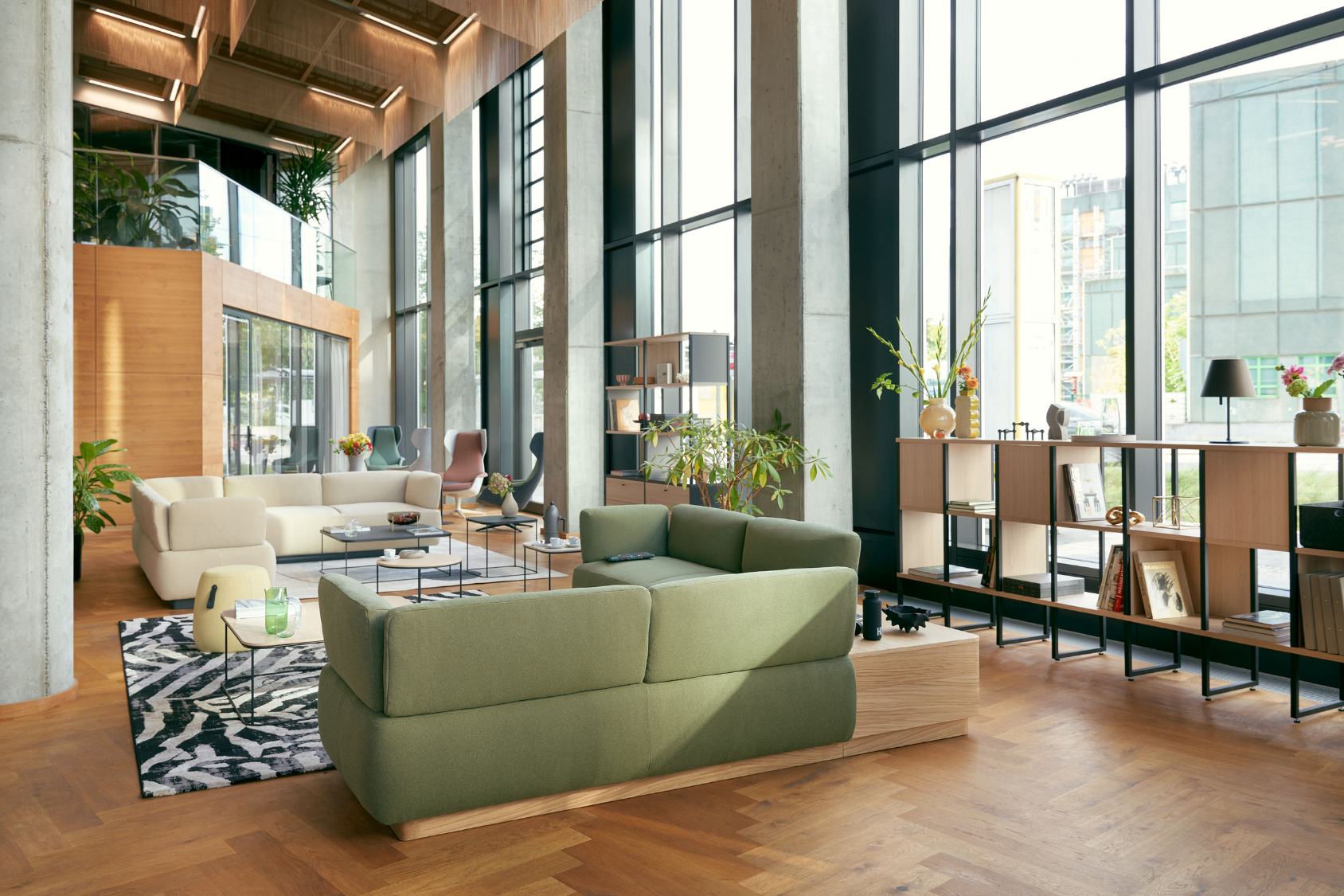 se:living Sofa, modernes Design mit klaren Linien und gepolsterten Armlehnen, zwei Sofas in grün und beige in hellem Wohnzimmer mit großen Fenstern