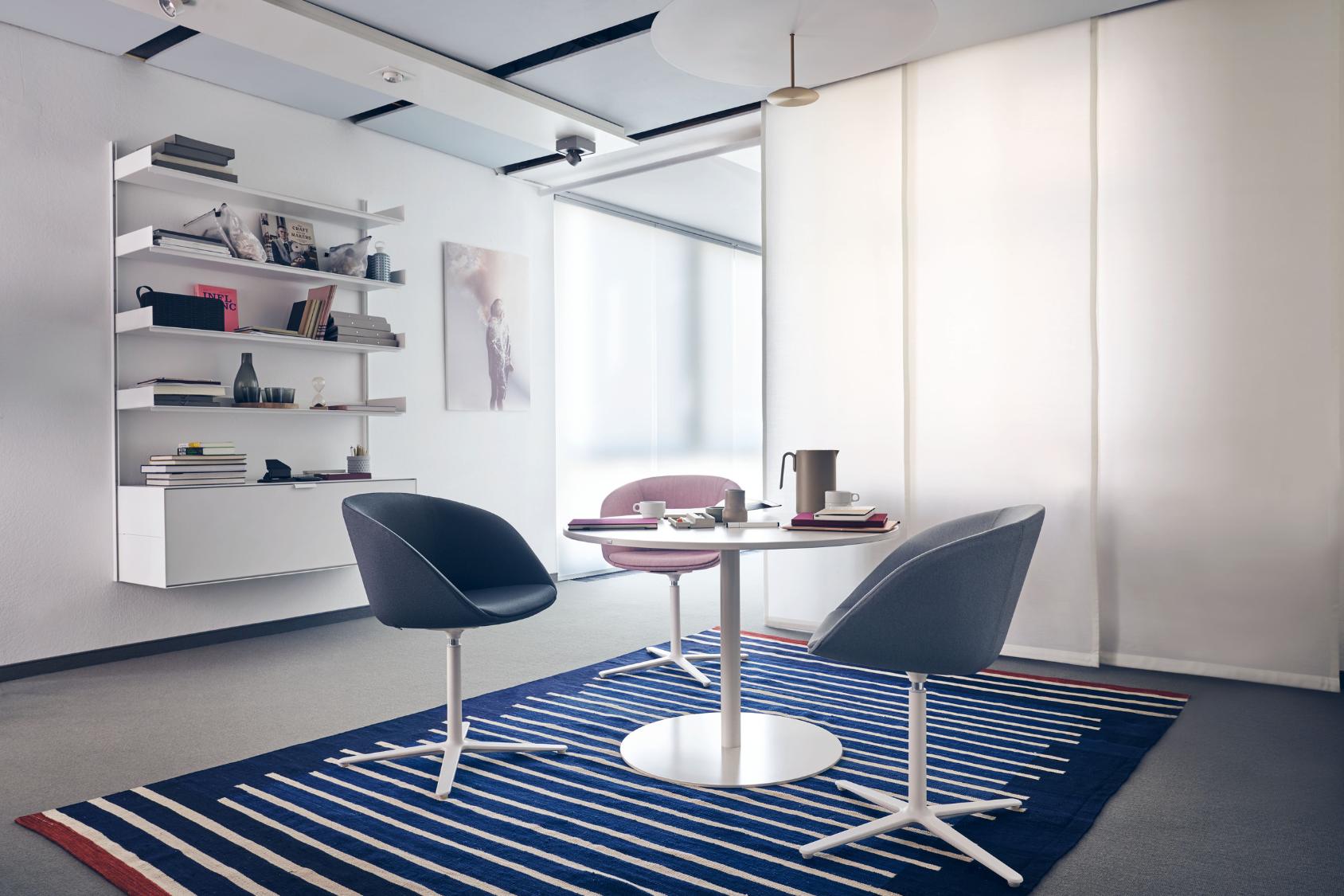 Drei on spot cosy Stühle in Grau und Rosa um einen runden weißen Tisch auf blau-weiß gestreiftem Teppich in modernem, hellem Raum