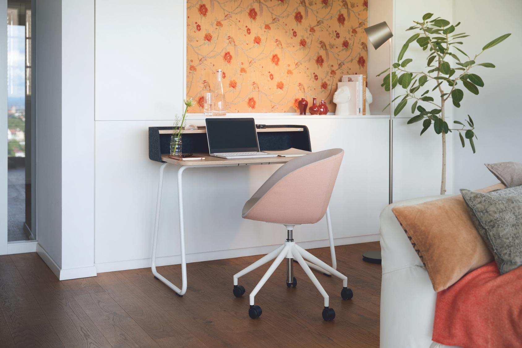 on spot cosy Bürostuhl mit rosa gepolsterter Sitzfläche und weißem 5-Fuß-Kunststoffgestell vor einem Wandarbeitsplatz mit Laptop und Blumenmuster-Tapete