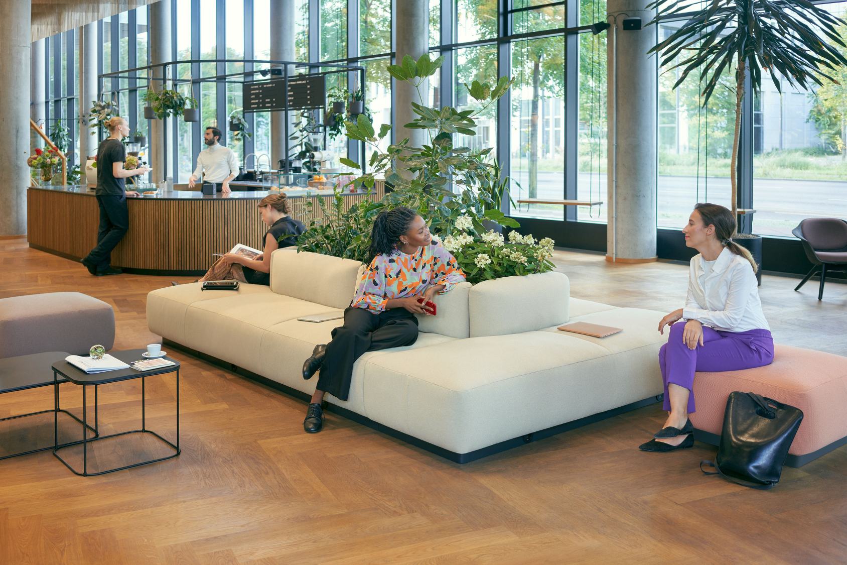 se:living Hocker in modernem, minimalistischen Design mit abgerundeten Kanten und rosa Polsterung, genutzt als Sitzgelegenheit in einem hellen, offenen Raum mit großen Fenstern und Pflanzen