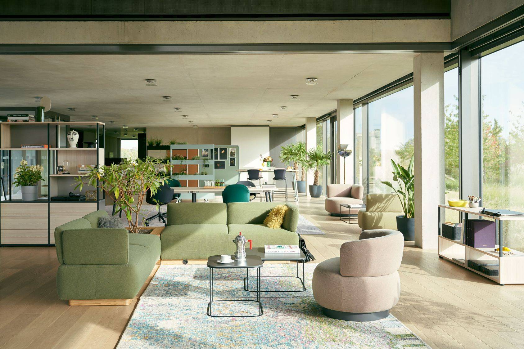 Moderner Wohnraum mit großem Fenster, grünem Sofa und rundem se:living Sessel in Beige auf Teppich